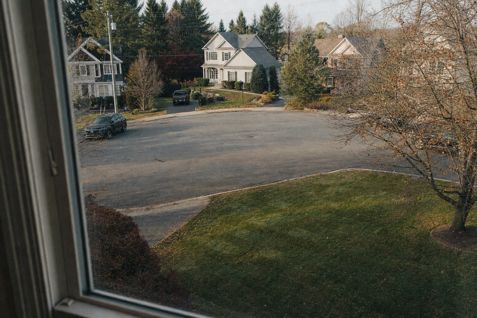 A modest two-story house on a quiet suburban street in early autumn